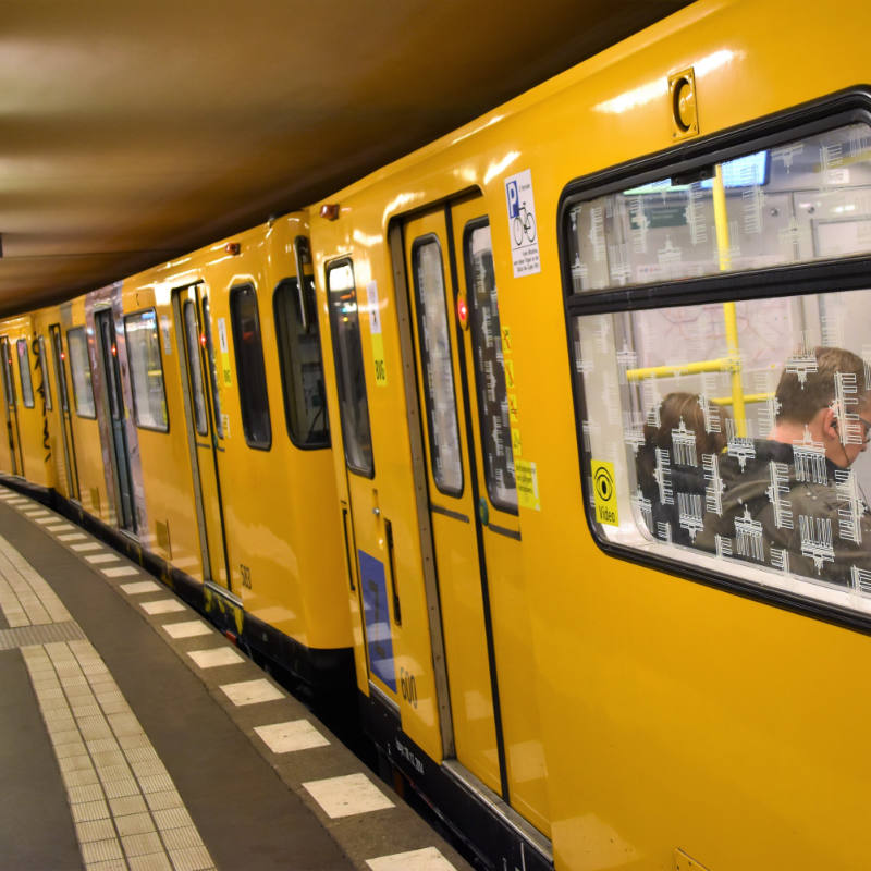 gelbe U-bahn an Station mit Menschen drin